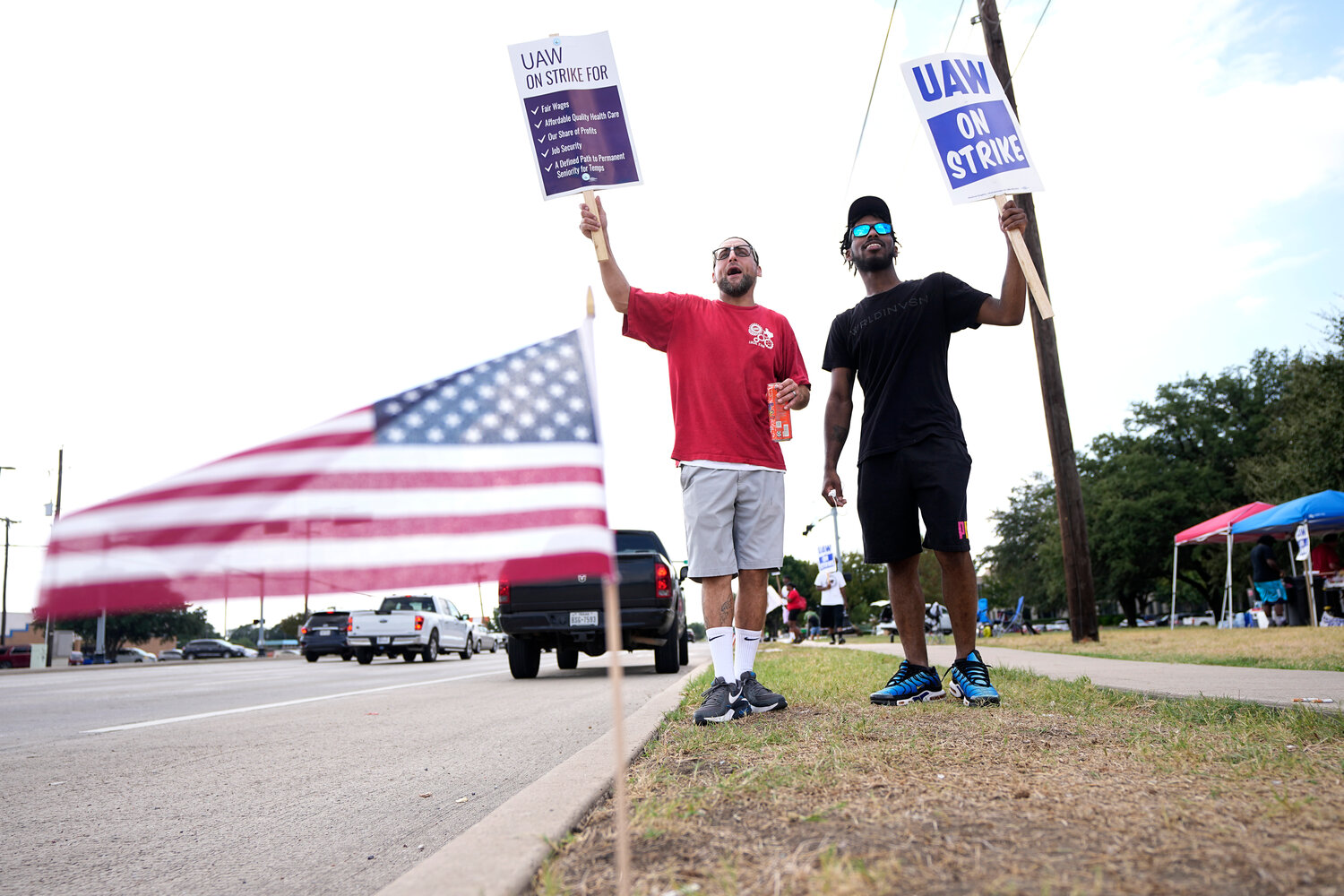 Philip Laws, left, and Robert Williams on a United Auto Workers picket line in front of a Stellantis distribution center in Carrollton, Texas, in September.