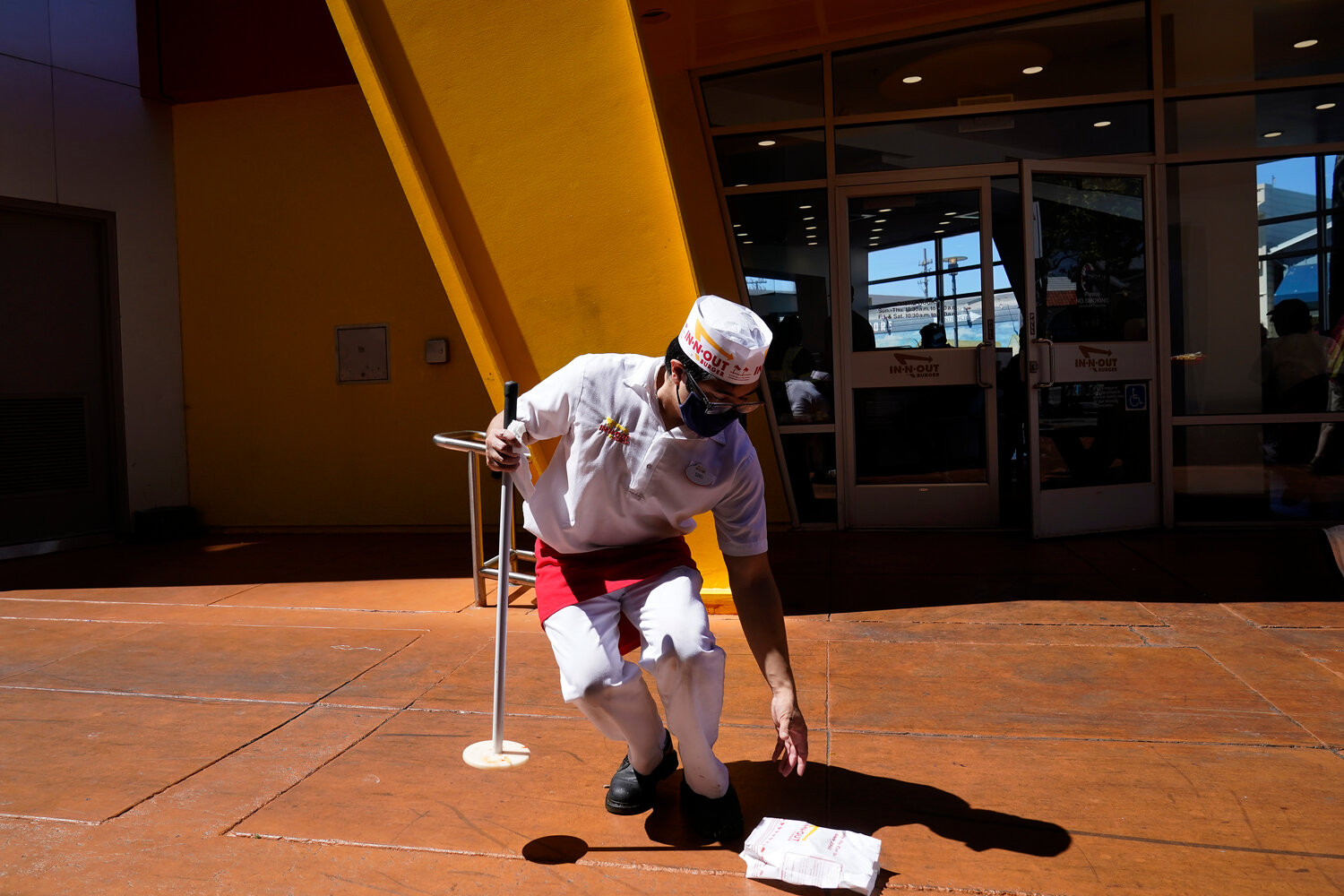 A worker cleaned up outside of an In-N-Out Burger restaurant in San Francisco Aug. 25, 2022. Recent raises for low-wage workers have reversed a lot of the wage inequality that has been growing for decades, even in states that did nothing to shore up the minimum wage.