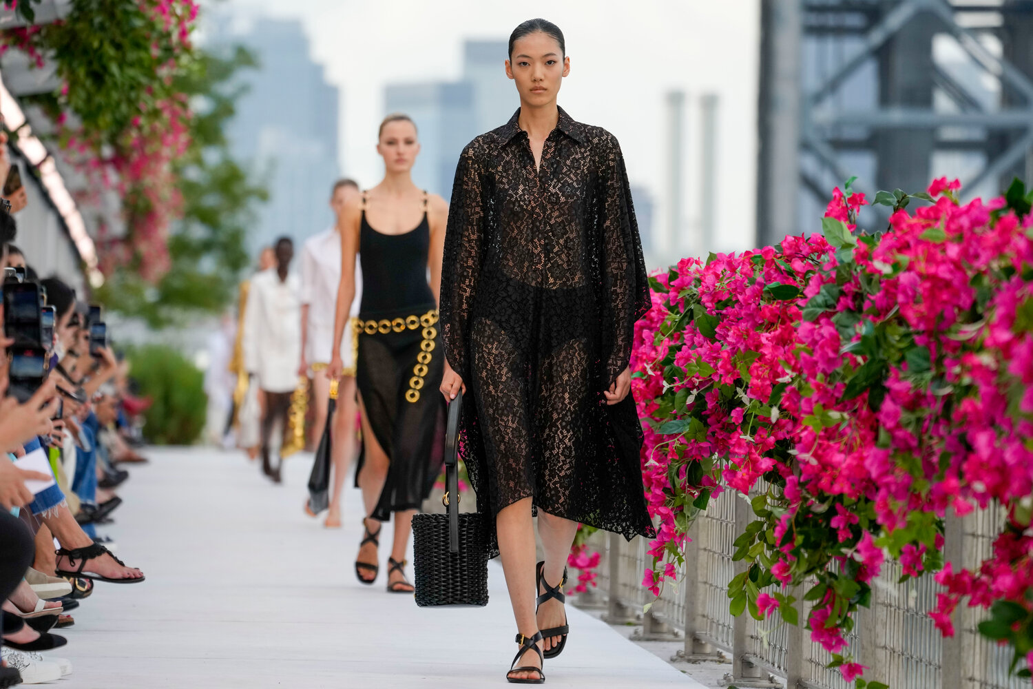Models walk a collection along an outdoor runway at Domino Park in Brooklyn during New York Fashion Week last September. Amended legislation introduced in the state legislature last week would provide basic protections for independent fashion models and also install prohibitions on management companies to use AI on a model’s digital replica without the model’s explicit permission.