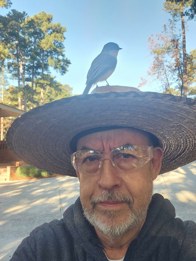 The bird rests on Ramiro Gaeta's hat.