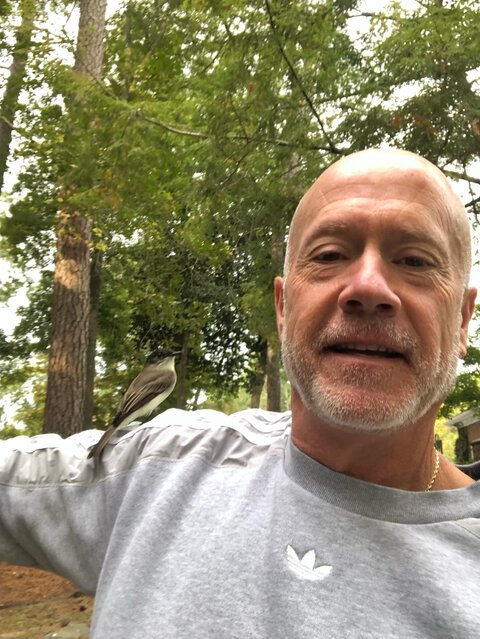 The friendly bird perches on Jim Smith's shoulder.
