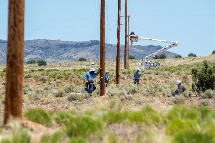 PWC crew members check out poles between a power line on the Navajo Nation. Lineworkers often worked on rural homesteads that were miles apart from one another.