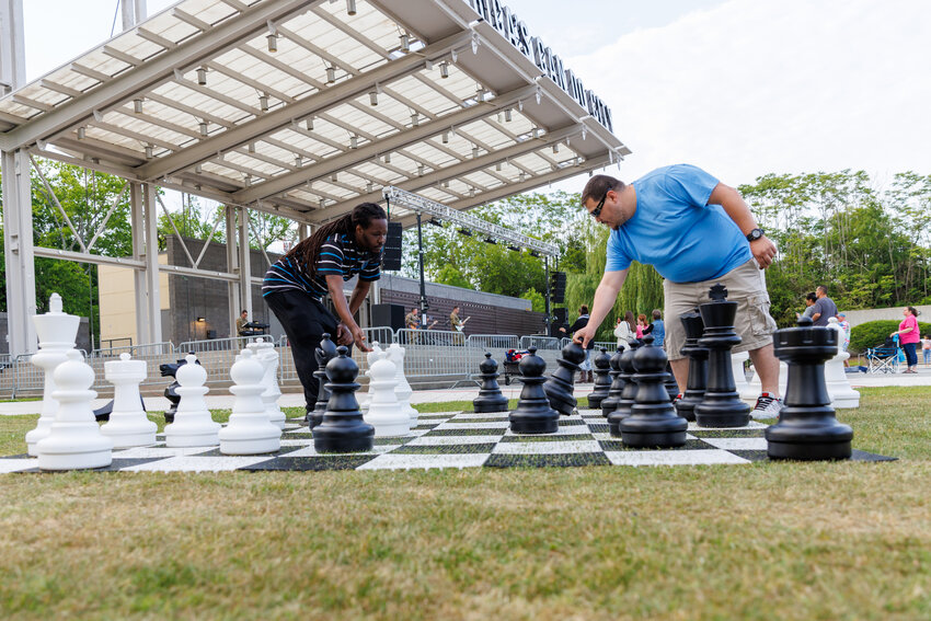 (L) Emmanuel Harrington and Tino Lopez play a game of chess as the 82nd Airborne Division All-American Rock Band plays a variety of hits during the 42nd annual Dogwood Festival on April 26, 2024. Photo: Tony Wooten