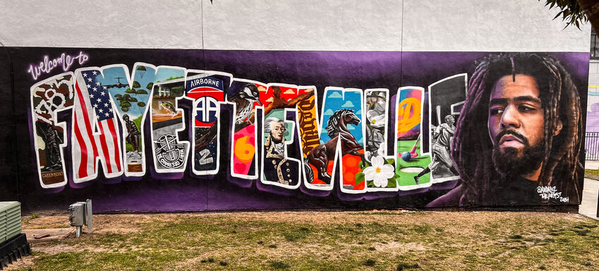 The mural of hip hop artist J. Cole, who grew up on Fayetteville, on Sunday, April 28, 2024. Efren Andaluz III, who goes by Andaluz The Artist, and his team painted the mural in early April on the side of Back-A-Round Records on the Market House square in downtown Fayetteville.