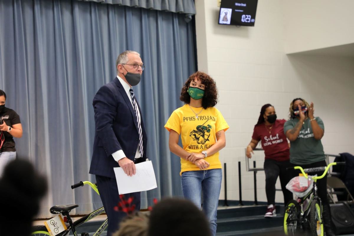Robert Krumroy, president of the Bikes for Kids Foundation, talks with Pine Forest High School senior Savannah Cotton during the assembly.