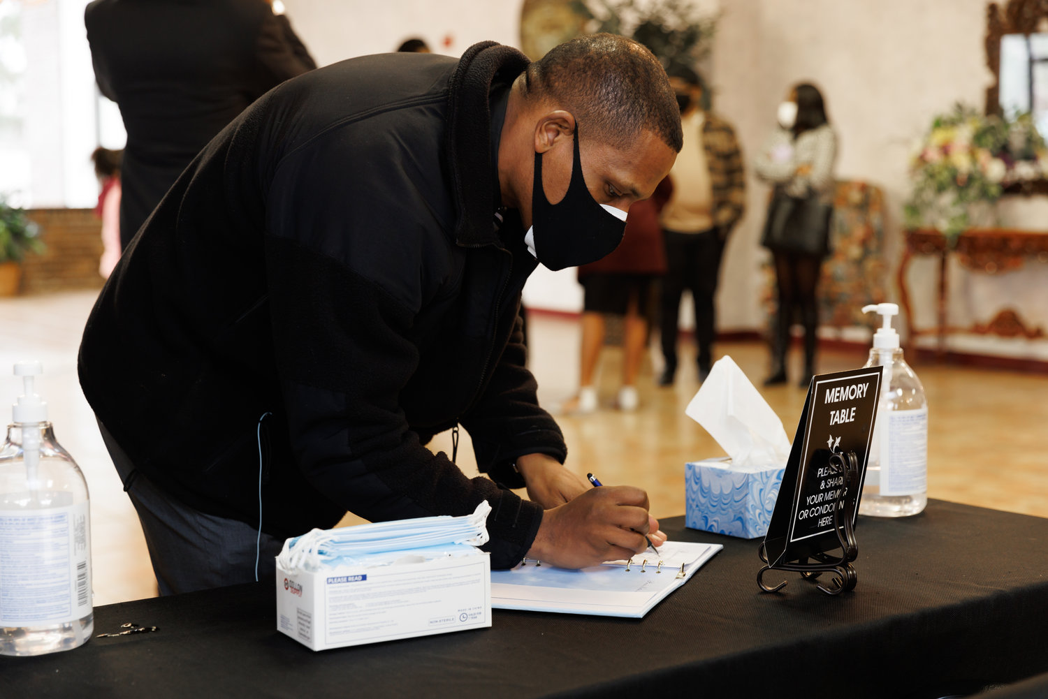 Shaun McMillian, co-founder of the Fayetteville Police Accountability Community Taskforce, signs the guest book at Jason Walker’s funeral Friday.