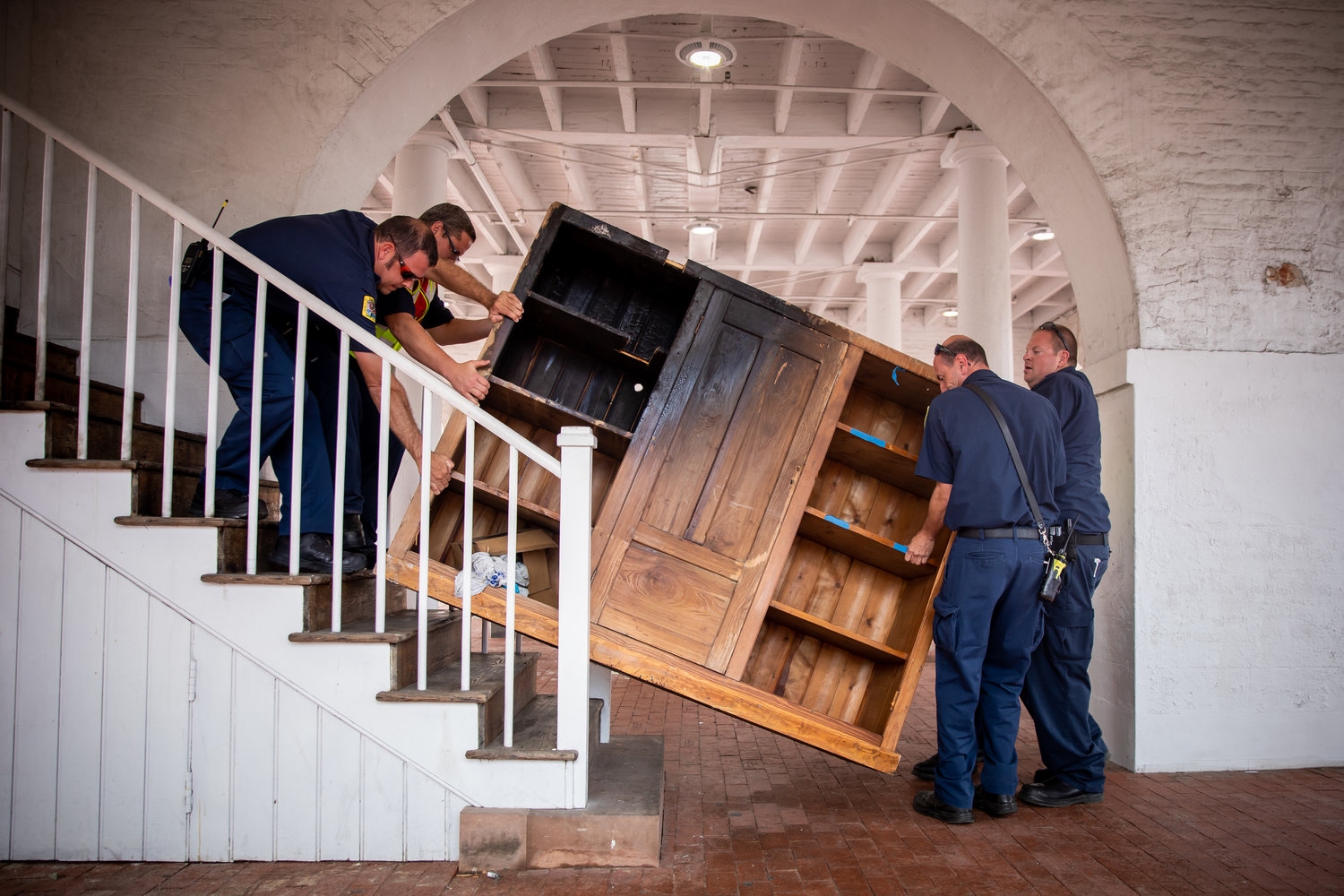 Members of the Fayetteville Fire Department help remove damaged furniture from the Market House on May 31, 2020.