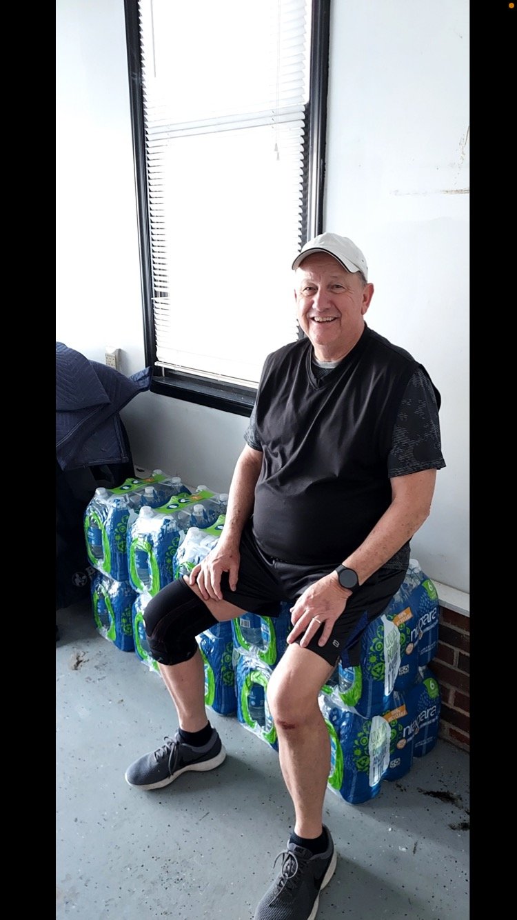 John Sweitzer sits on cases of bottled water at his home in northeastern Cumberland County after his well tested positive for a type of forever chemical known as PMPA.