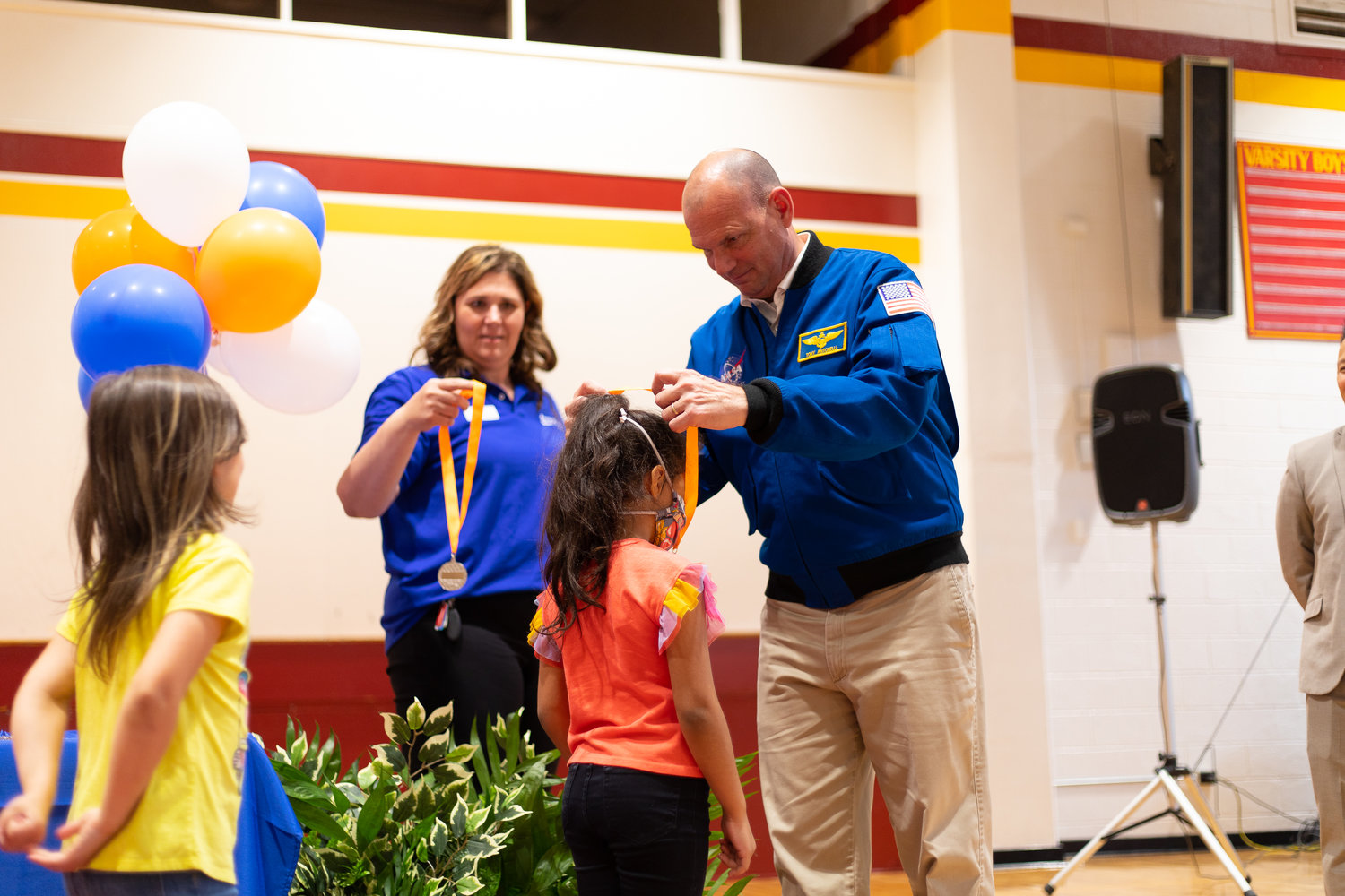 Tony Antonelli places a medal on Jr. Astronaut Design Challenge winners from Cumberland Mills Elementary School.