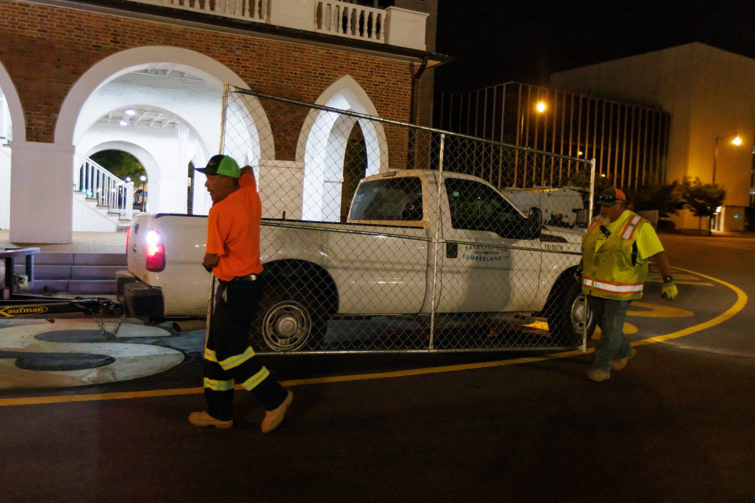 Workers with Fayetteville-Cumberland Parks & Recreation remove the fencing early Thursday from around the Market House.
