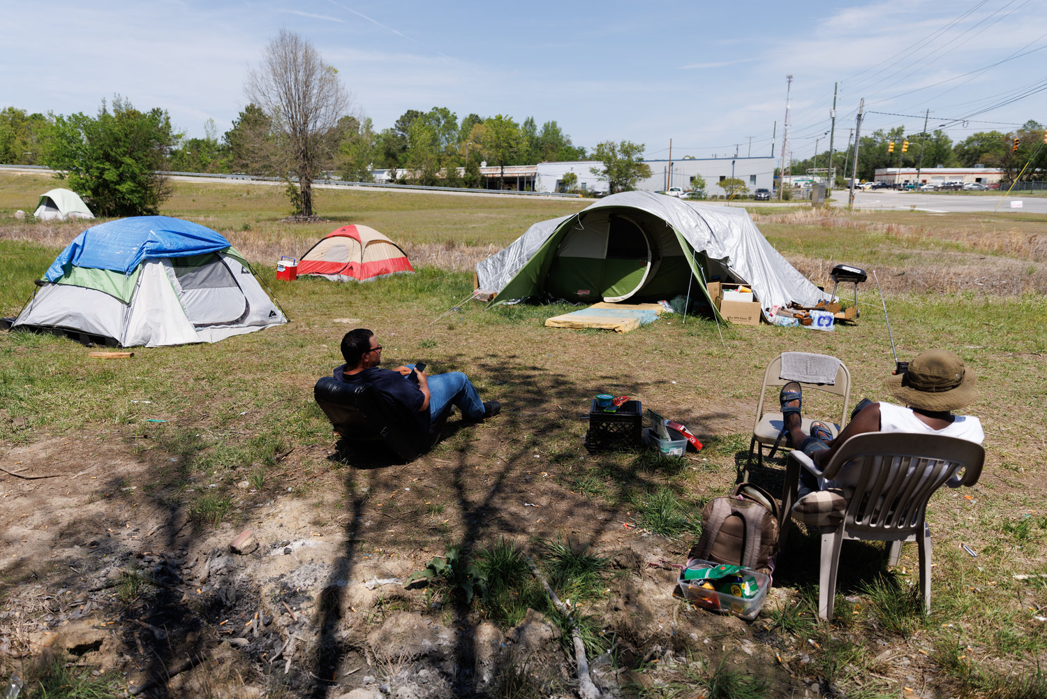 Two men share their stories at a homeless camp off Gillespie Street.