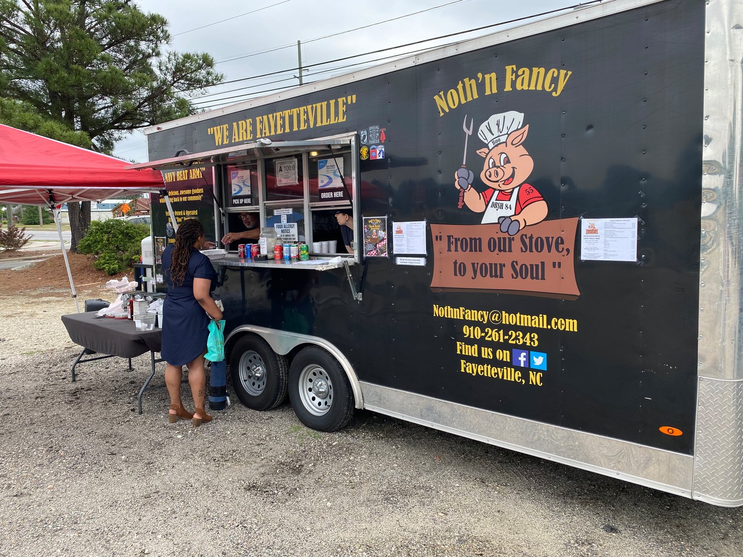 Candice Cameron, 40, of Fayetteville, orders smoked chicken wings, baked beans and macaroni and cheese from Noth'n Fancy food truck at the Murchison Road Food Truck Park in Fayetteville on Thursday. The Murchison Road Food Truck Park is open Fridays and Saturdays, from 11 a.m. to 6 p.m.