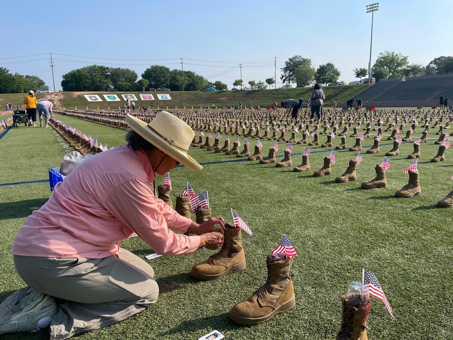 Martha Brown helps set up the display Friday at Hedrick Stadium on Fort Bragg. 'I feel honored that I was chosen to be one of the volunteers to kneel and put the tags on the boots,' said Brown, who moved to Fayetteville 30 years ago and now works for Army Community Services.