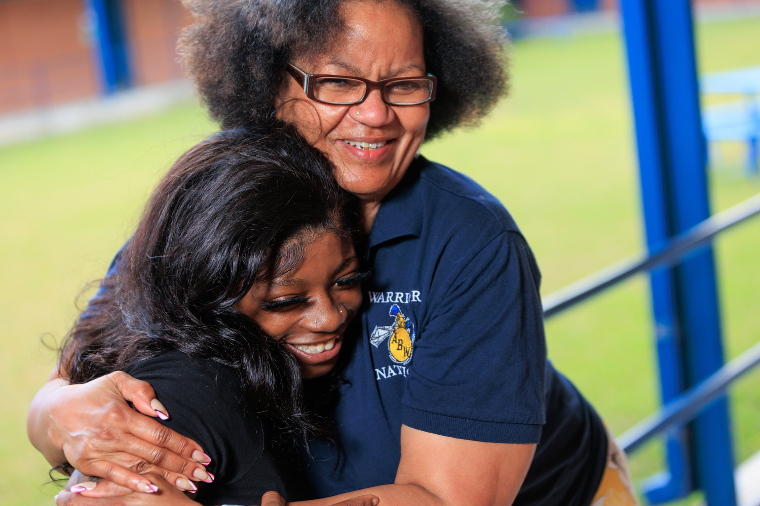 Zakira Cruz, counselor at Wilkins High School, hugs Aiana Abron, who is among 17 students named Standout Seniors 2022 by Cumberland County Schools.