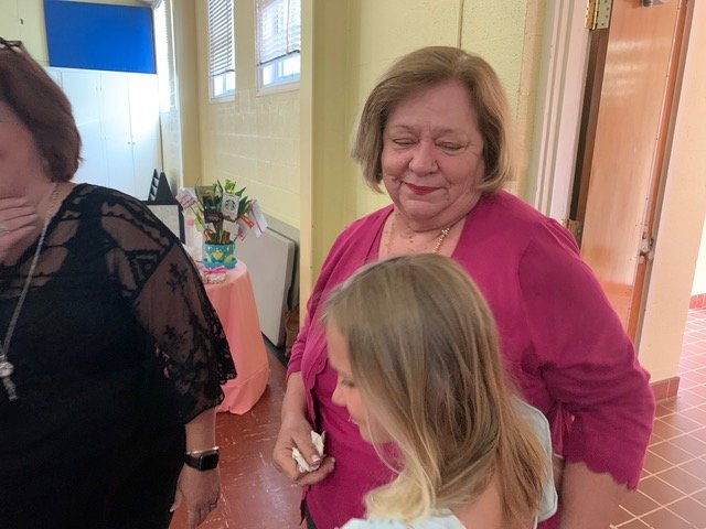 Reagan Brady, 8, gives a hug to her former teacher Friday night during a surprise reception at Alma Easom Elementary School. She was Debra Taft's student in 2020-21.