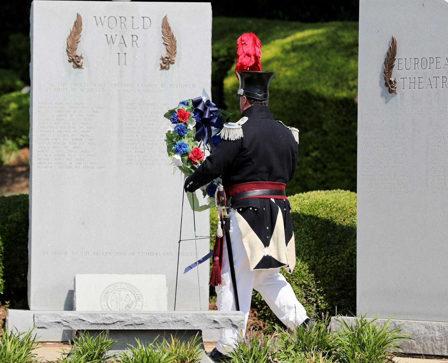 A member of the Fayetteville Independent Light Infantry lays a wreath at the World War II memorial during the Memorial Day ceremony at Freedom Memorial Park.