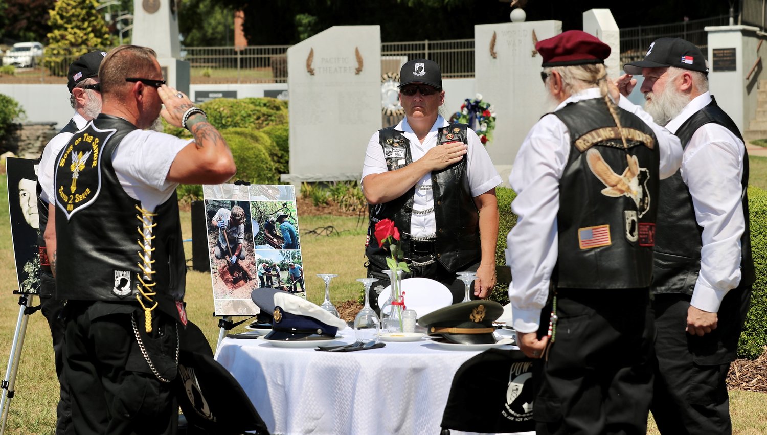 Members of Chapter One of Rolling Thunder place hats representing fallen service members at the Missing Man Presentation Table during a Memorial Day ceremony at Freedom Memorial Park.