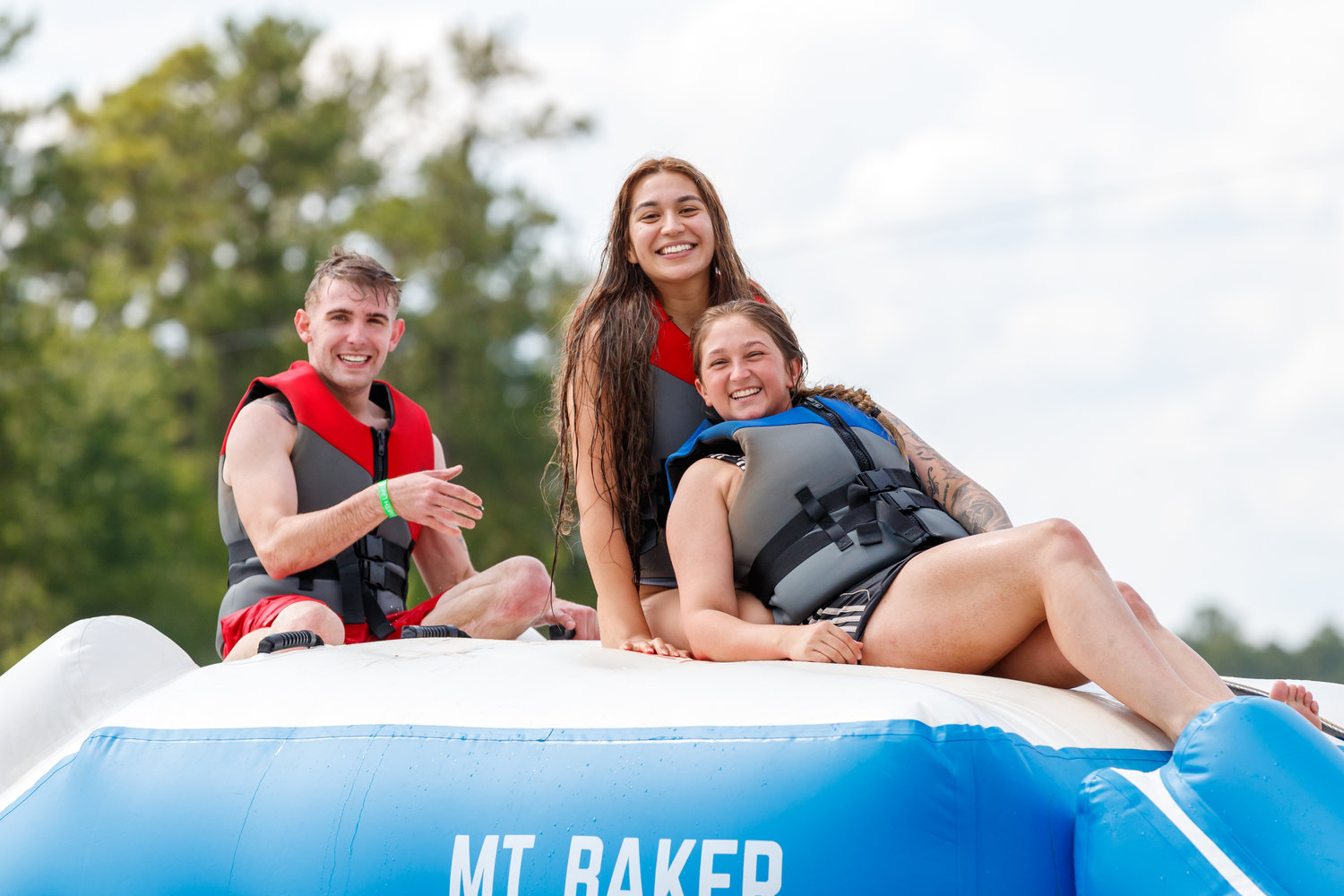 Nathan Grassie, Cynthia Vanegas and Merrisa Summers prepare to slide into the water at Smith Lake.