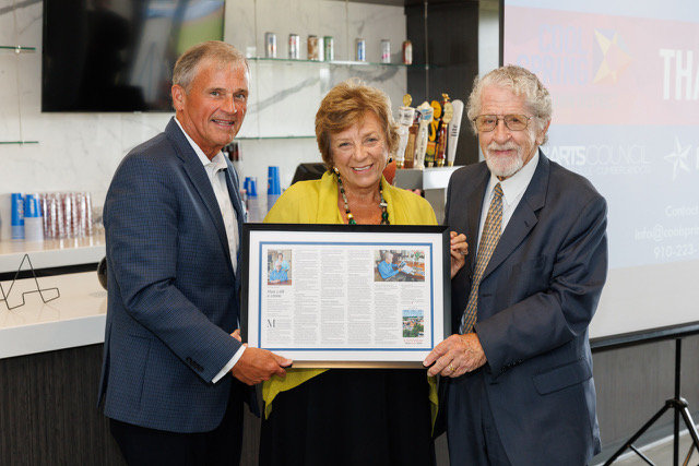 Tony Chavonne, left, presents the 2022 CityView Downtown Visionary award to Suzanne and Dr. Menno Pennink during a luncheon Wednesday at Segra Stadium. Menno Pennink was recognized for his work revitalizing downtown.