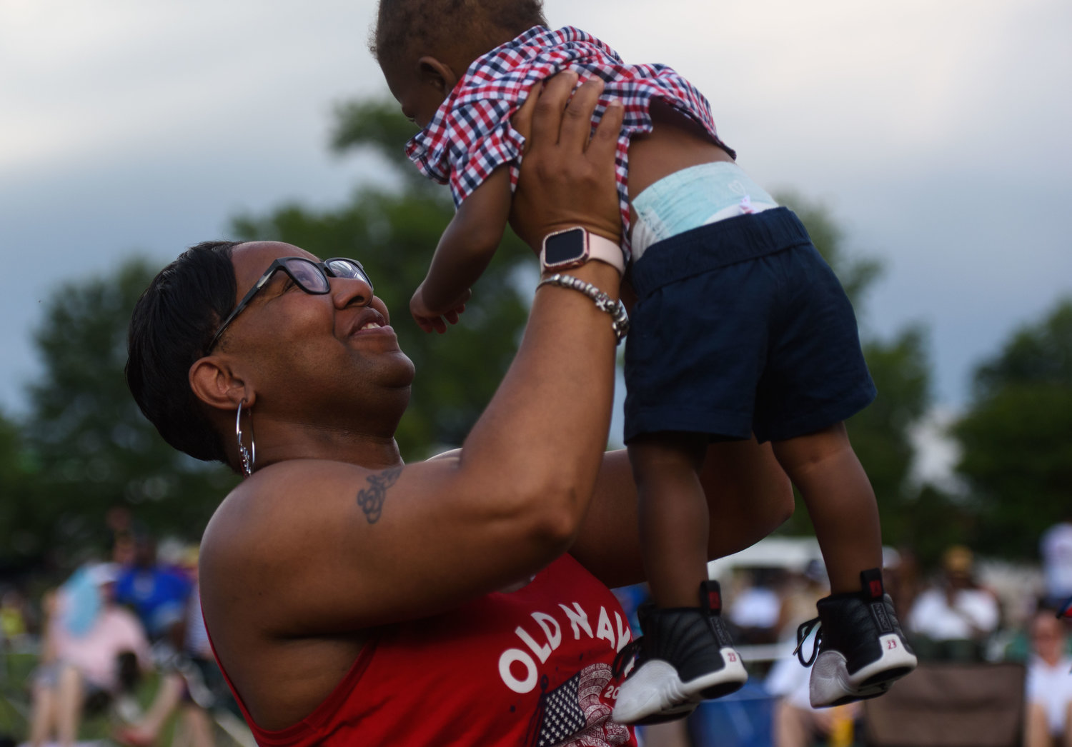 Denise McMillan lifts 1-year-old Jasia Grant while spending time with friends at Festival Park during the Independence Day celebration in Fayetteville on Monday.