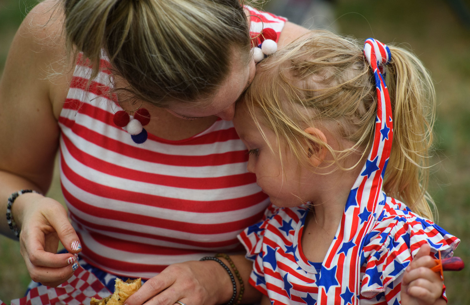 A mother and daughter share a snuggle during the Independence Day celebration at Festival Park on Monday.