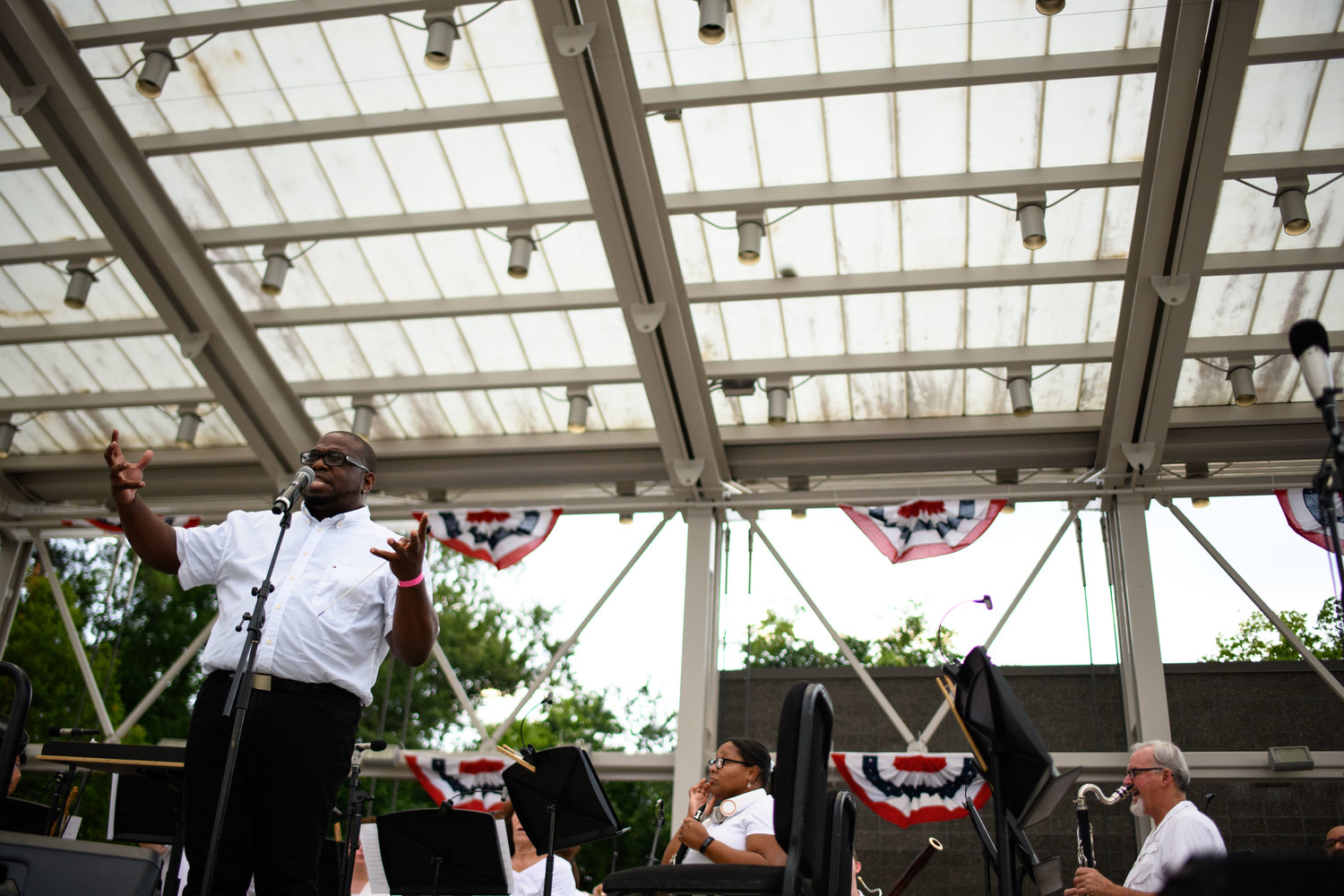 The conductor for the Fayetteville Symphony Orchestra speaks to the crowd as part of the Independence Day celebration at Festival Park on Monday.