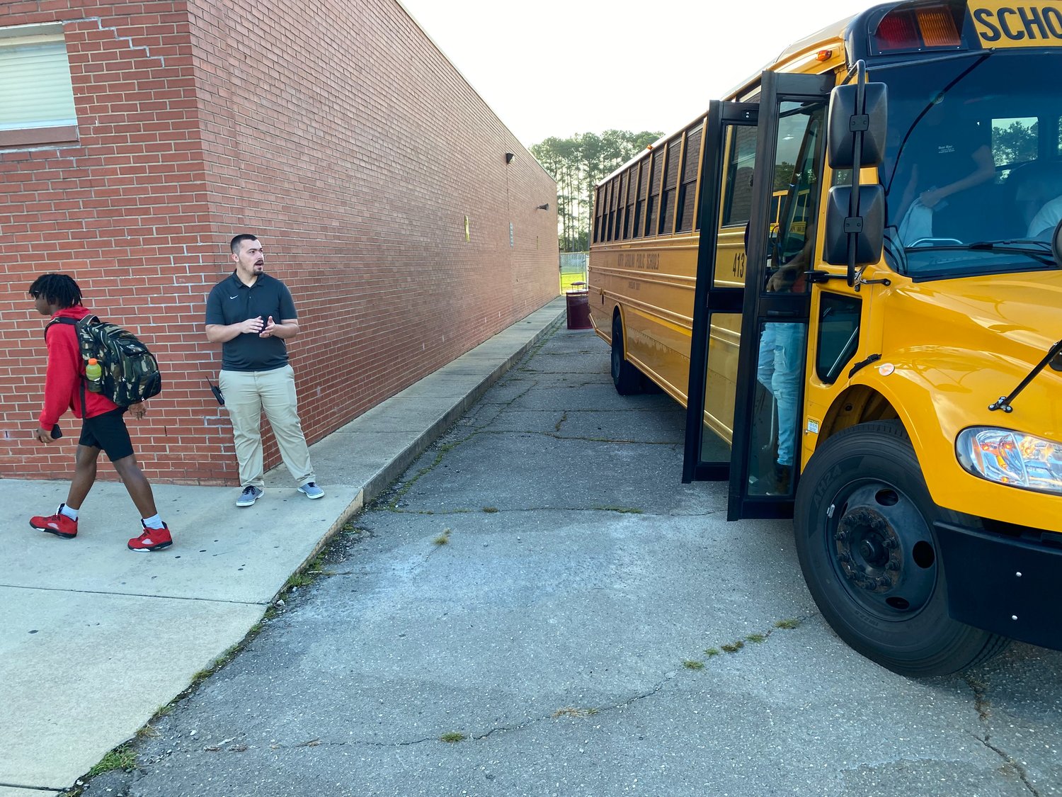 Students at Anne Chesnutt Middle School exit the school bus on the first day of year-round school on Monday.