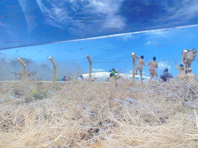 Somalia Danab brigade commandos climb a fence to evacuate passengers from a Jubba Airlines aircraft that crash-landed Monday at the Mogadishu International Airport. Three Fort Bragg soldiers with the Army's 2nd Security Force Assistance Brigade helped care for injured passengers, the Army said.