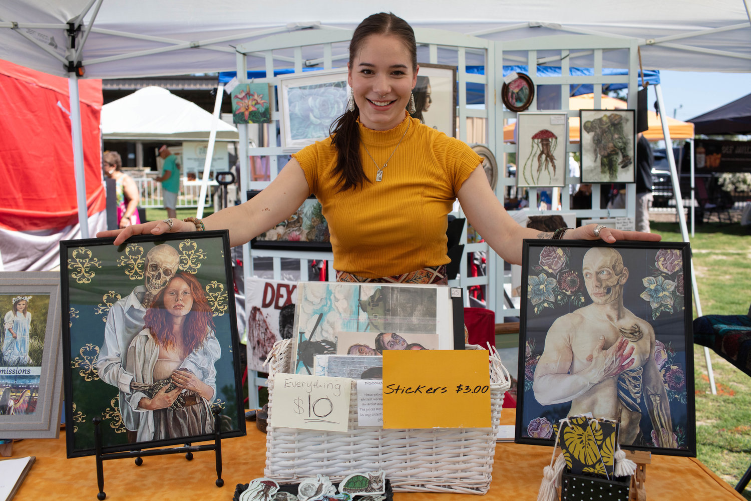 Artist Naomi Raber of Little Yellow Book Artwork shows off a few of her beautiful works for sale at her booth amongst the vendors at Dirtbag Ales.