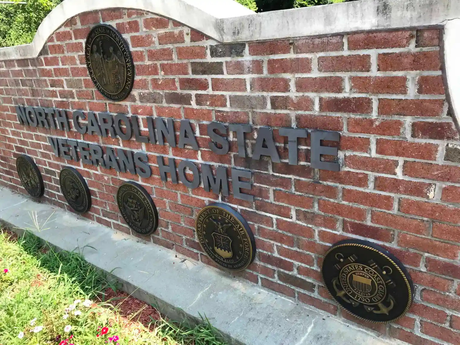 The North Carolina State Veterans Nursing Home in Fayetteville displays icons of the U.S. military branches of service. The facility went through a COVID-19 outbreak that killed 20 veterans who were living there.