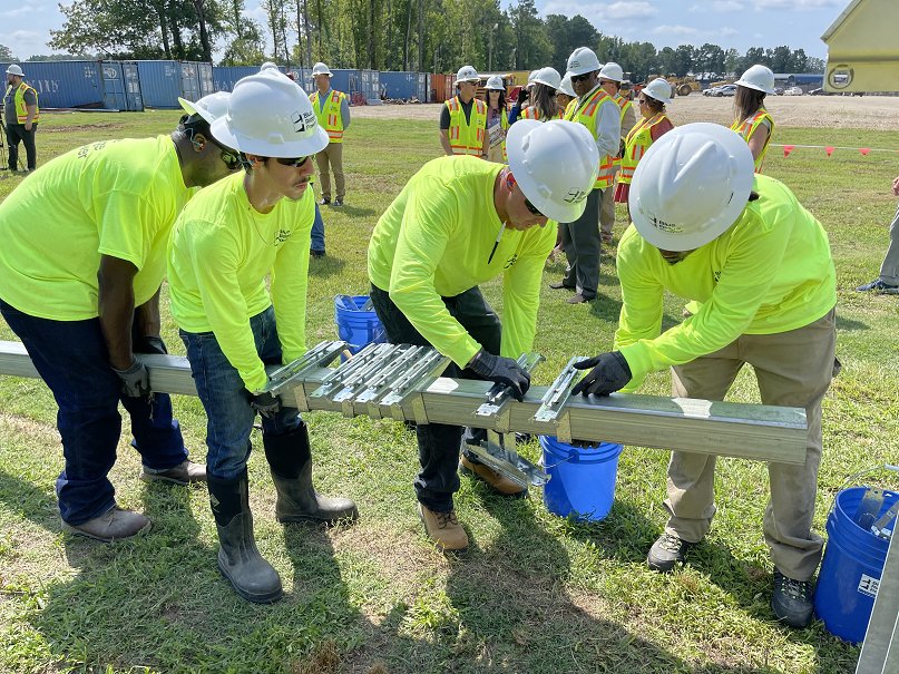 Students in a one-week PowerUp Academy training program demonstrate construction of a solar array at Blue Ridge Power in Fayetteville.