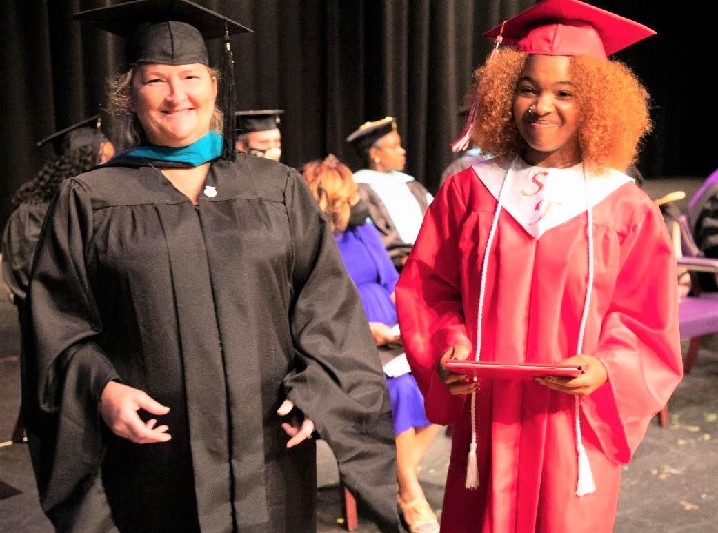 A Seventy-First High School graduate receives her diploma from a school administrator during Cumberland County Schools' summer graduation Thursday at Jack Britt High School.