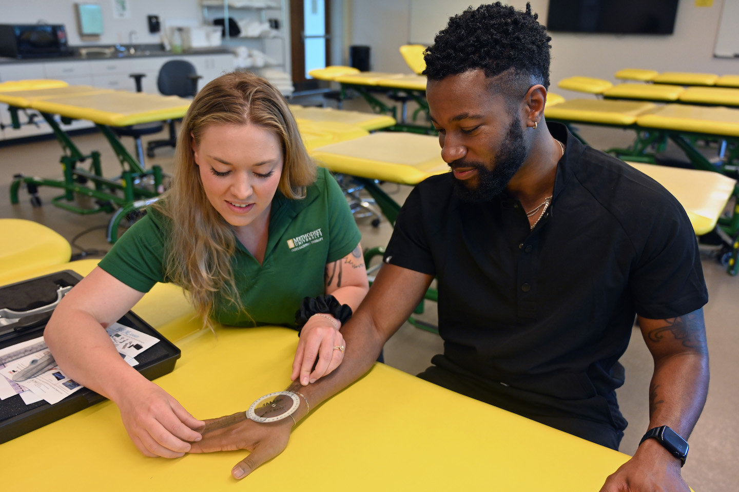 Katelyn Del Angel, left, and Cameron Harris – students in Methodist University's Doctor of Occupational Therapy program in 2021-22 – practice various techniques used in the career field.