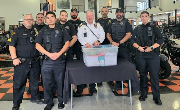 Fayetteville Police Department officers bought school supplies to donate to children in need at a giveaway at Fort Bragg Harley Davidson on Saturday.