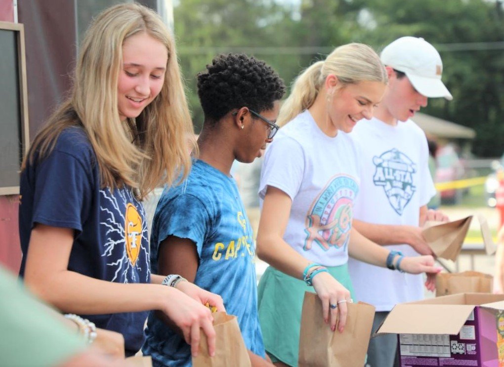 Students assemble meals for the back-to-school giveaway at Balm in Gilead's Doc Bennett Road campus on Monday.