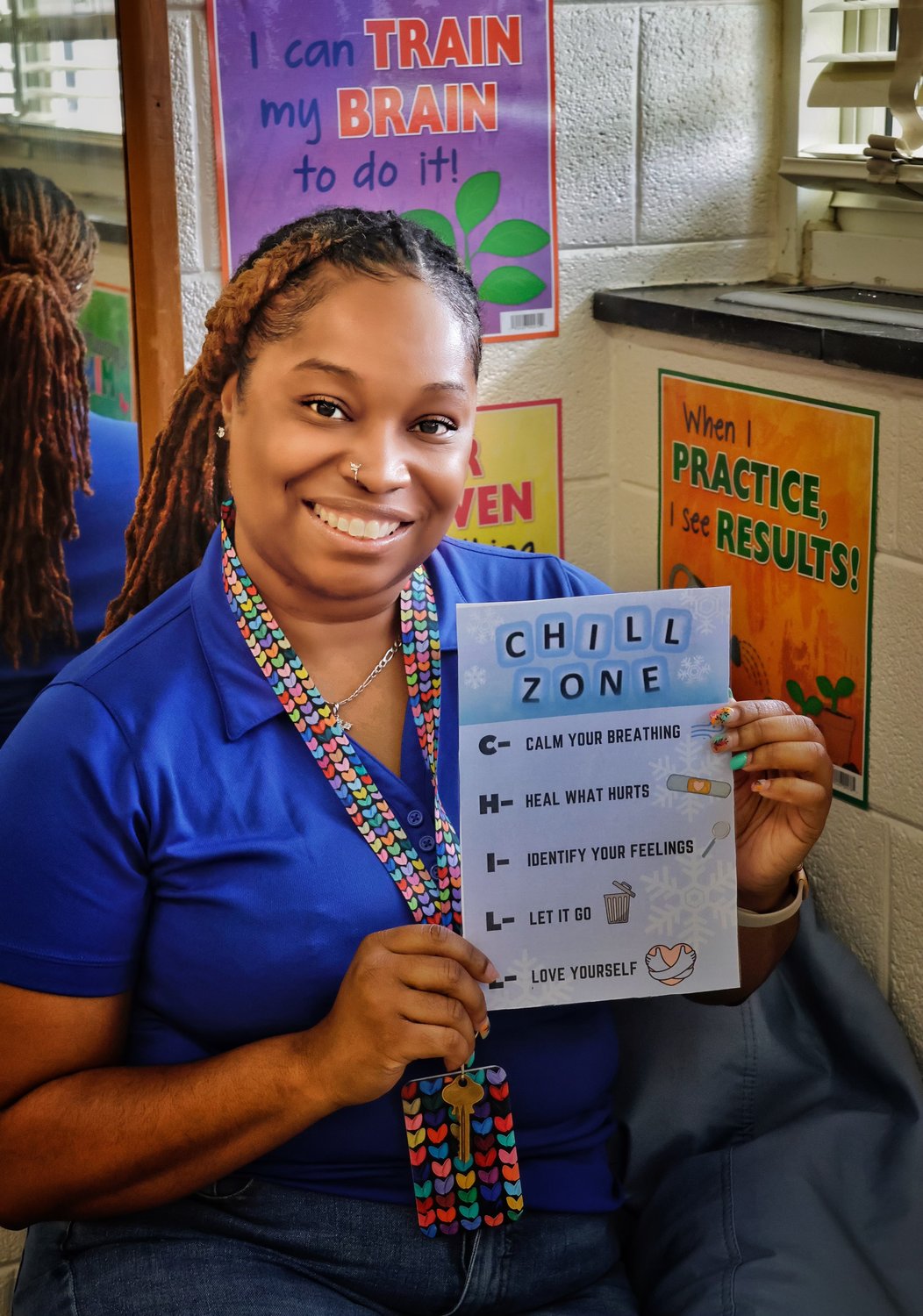 Briana Smith holds a Chill Zone poster while sitting in the chill zone bean bag in her class at Ferguson-Easley Elementary School. Smith was working in her classroom on Friday and preparing for students to return on Monday.