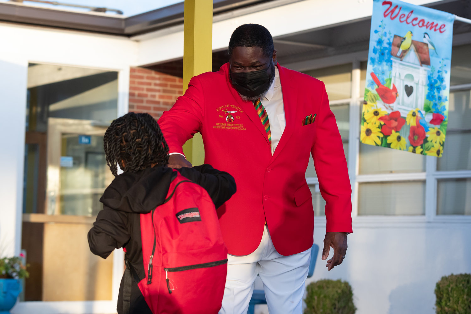 Members of the Kindah Temple No. 62 greet students as they arrive for the first day of school at Ferguson-Easley Elementary School on Monday.
