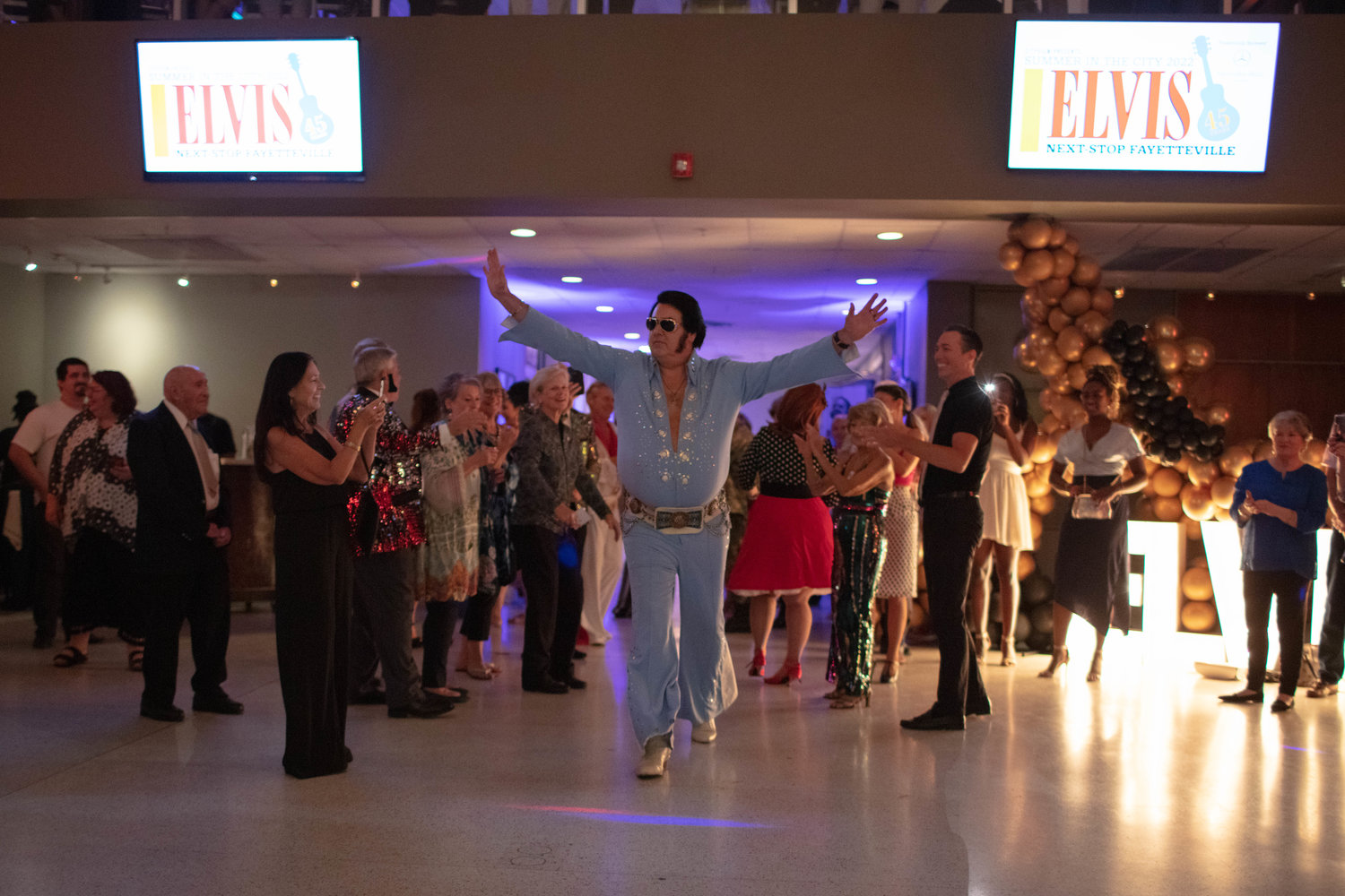 Elvis tribute artist David Chaney makes an entrance before performing.