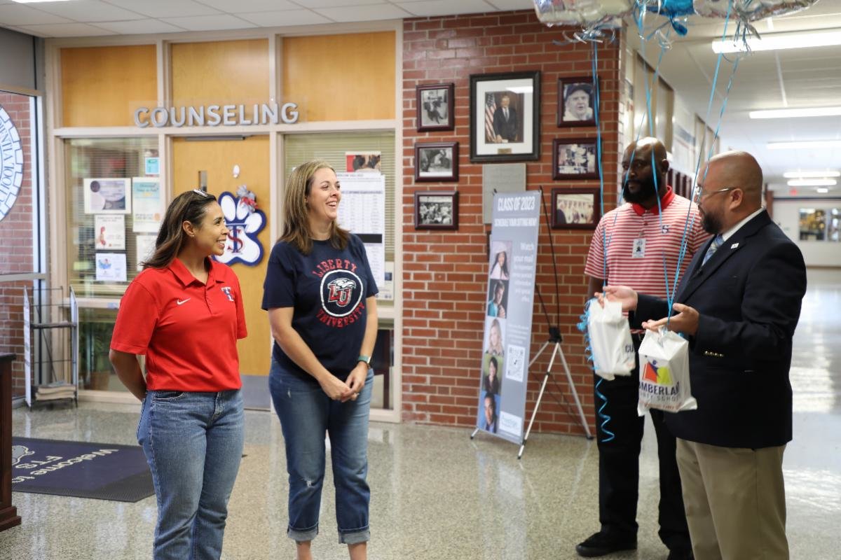 Ruben Reyes, the associate superintendent of Human Resources, presents the August 2022 Extra Mile Award to Emonique Grevel and Tracy Rowland at Terry Sanford High School.