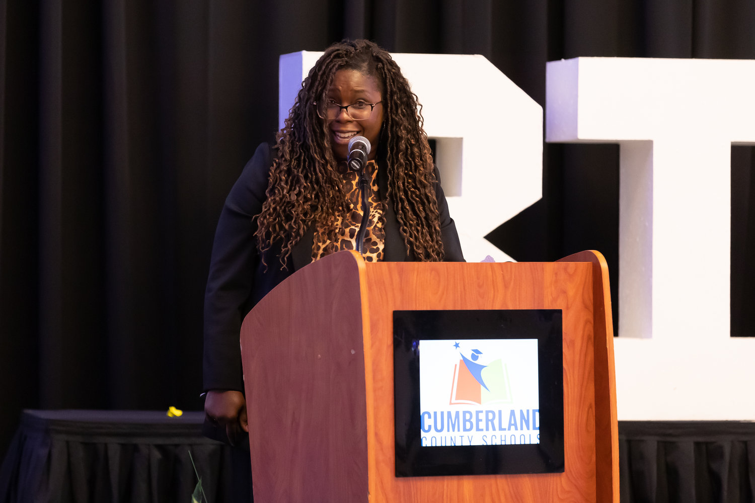 Talicia Smith, a science teacher at Douglas Byrd Middle School, addresses the audience after being named the Cumberland County Schools 2023 Teacher of the Year during a program Monday night at the Embassy Suites Fayetteville-Fort Bragg.