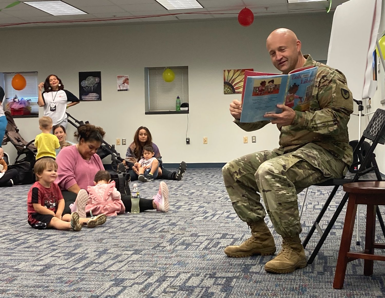 Col. John Wilcox, the Fort Bragg garrison commander, reads 'Lola at the Library' by Anna McQuinn during the 25th anniversary celebration of Throckmorton Library on Fort Bragg on Wednesday.