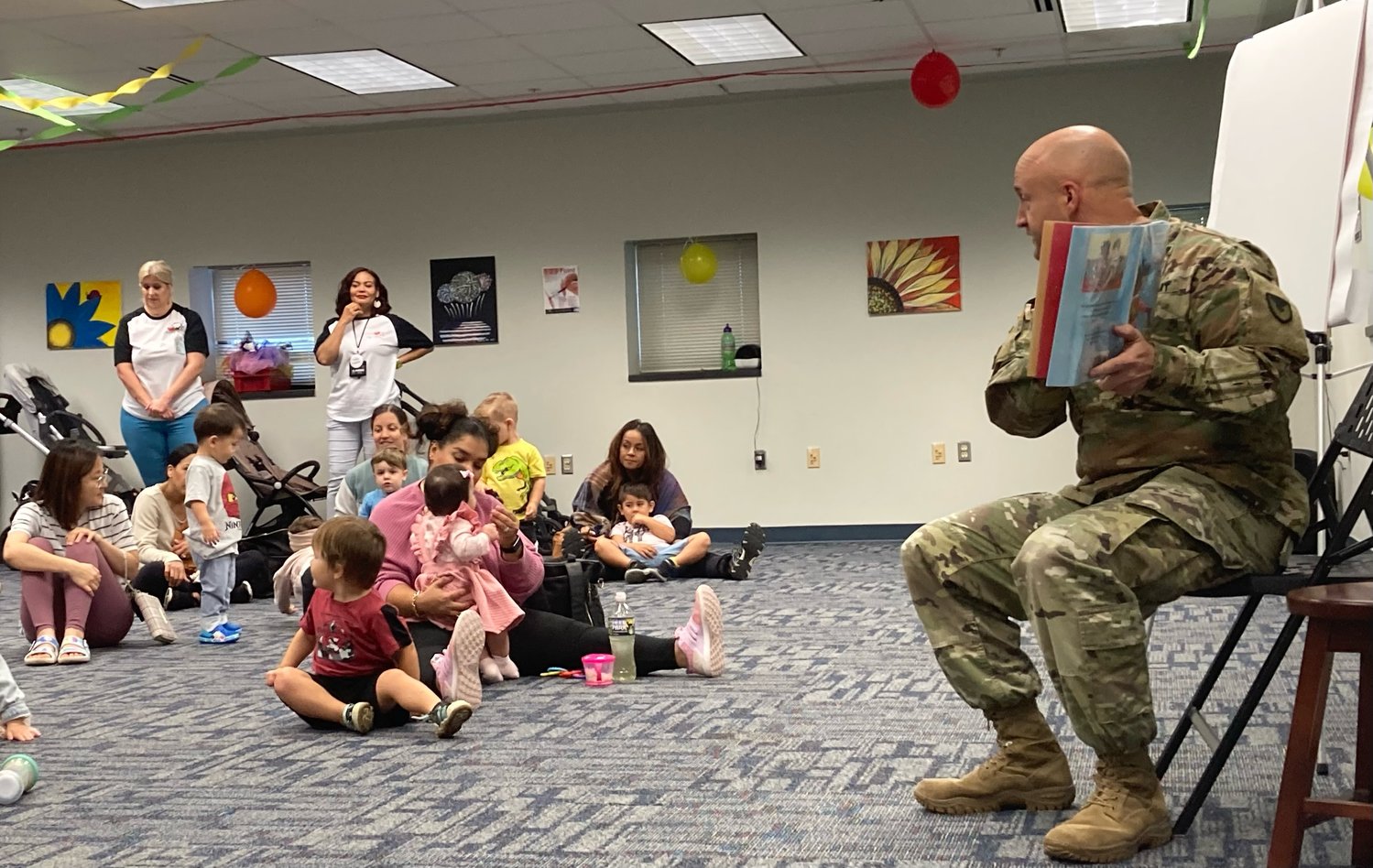 Col. John Wilcox, the Fort Bragg garrison commander, reads 'Lola at the Library' by Anna McQuinn during the 25th anniversary celebration of Throckmorton Library on Fort Bragg on Wednesday.
