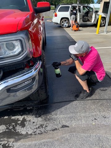 A worker glosses tires at Flawless Touch Detailing.