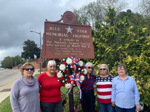 Connie Michaels, Gerri Arrowood, Shelton Shearon, Debbie Nepstead and Polly Strickland of the Cross Creek Briarwood Garden Club place a Veterans Day wreath at the Blue Star Highway Marker at Freedom Memorial Park.