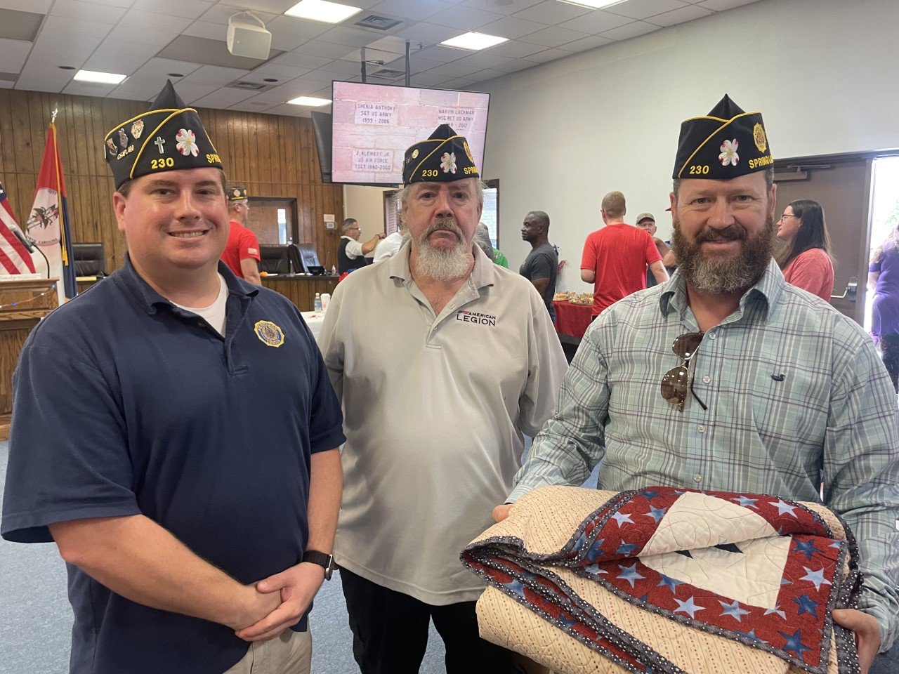 Chaplain Aaron Jeffers, Commander Armand Caron and first Vice Commander Derek Orent, members of American Legion Post 230, show a quilt that will be presented to retired Sgt. Maj. Charles L. Miller at a later date.