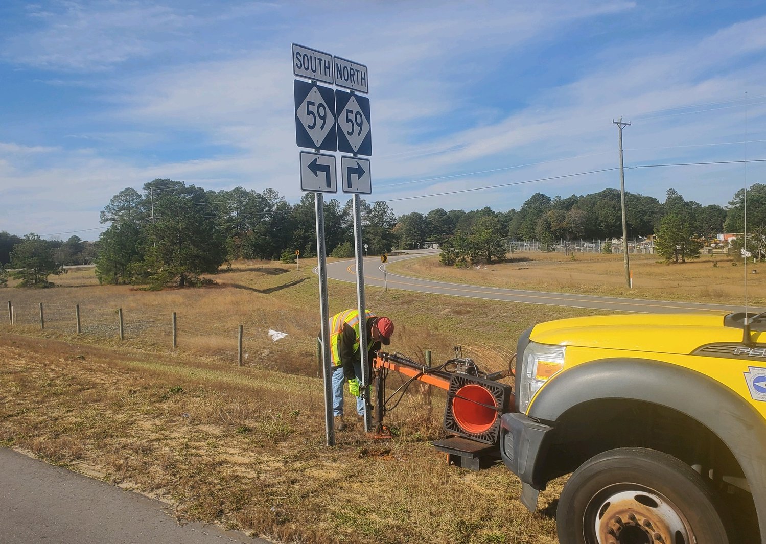 N.C. Department of Transportation employees on Monday remove N.C. 59 signs near the U.S. 301 exit in Hope Mills.
