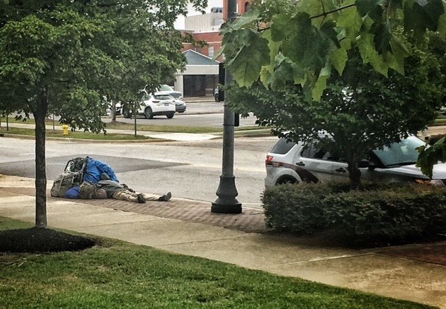 A homeless person sits outside the Cumberland County Public Library. The Cumberland County Board of Commissioners voted 5-2 Monday in favor of two new ordinances designed to remove homeless individuals from parking or camping on county-owned property. The proposed ordinances will require a second reading.