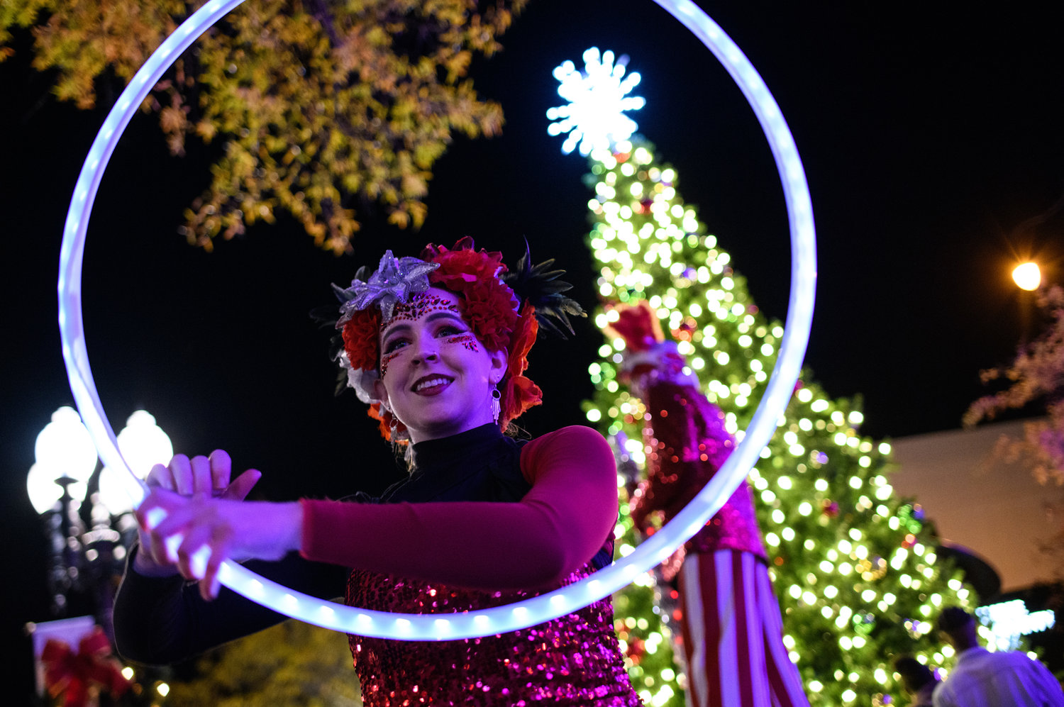 A performer for Imagine Circus performs with a hula hoop during Holidays on Hay on Friday in downtown Fayetteville.