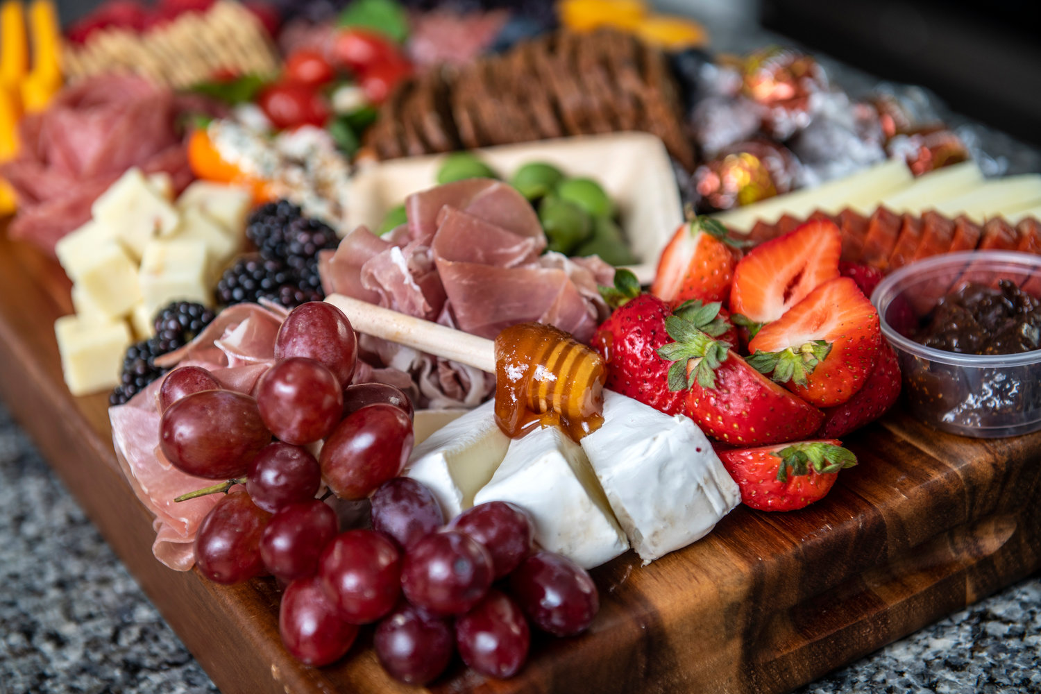 A swirl of honey adds flavor to chunks of brie in a charcuterie board created by Lindsey Smith of The Charcuterie Chic.
