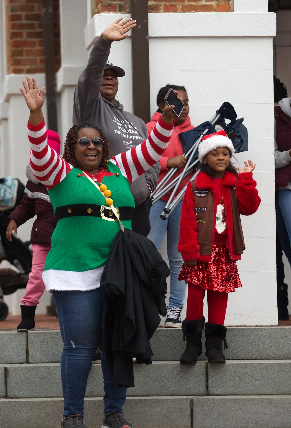 People wave as the Fayetteville Rotary Christmas Parade moves through downtown Fayetteville on Saturday.